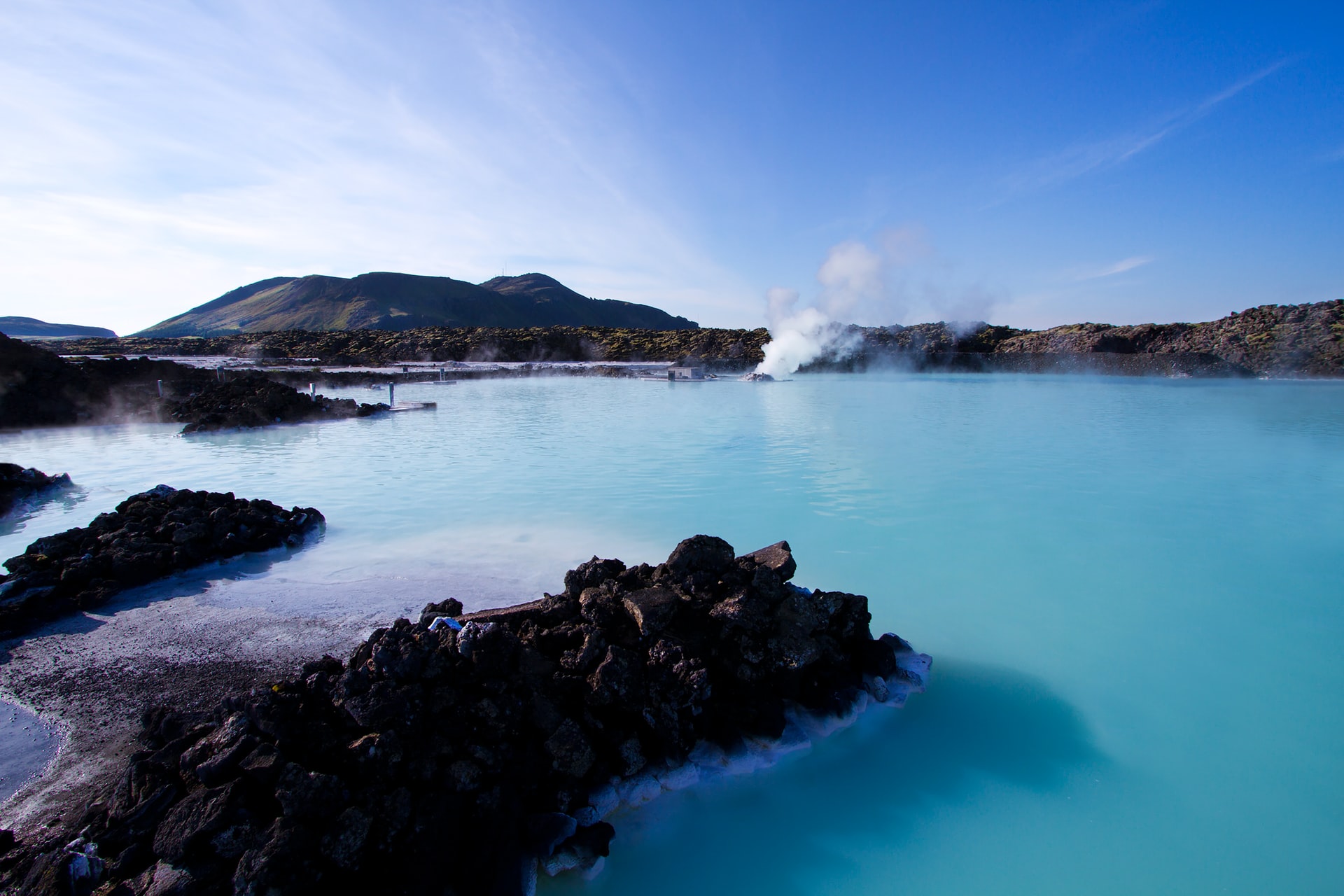 Image shows the blue lagoon in Iceland with blue skies above